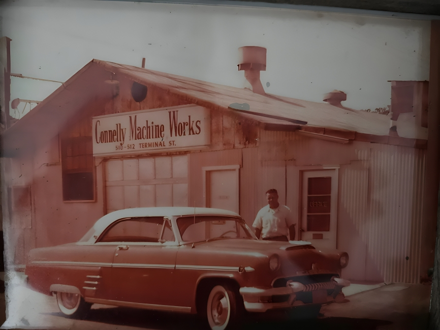 Original Connelly Machine Works building in 1946 with Leroy Connelly and vintage car